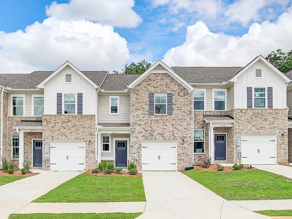 New construction townhome with brick accents and attached garage at Avery Landing in McDonough, GA