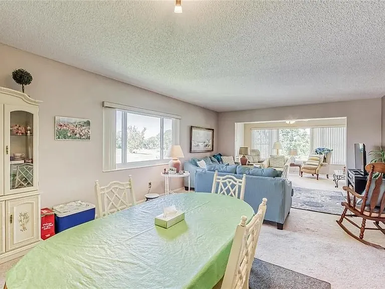 Dining area is in the forefront; living room and Florida room are in the background.

 *This unit is unfurnished. All furniture has been removed.