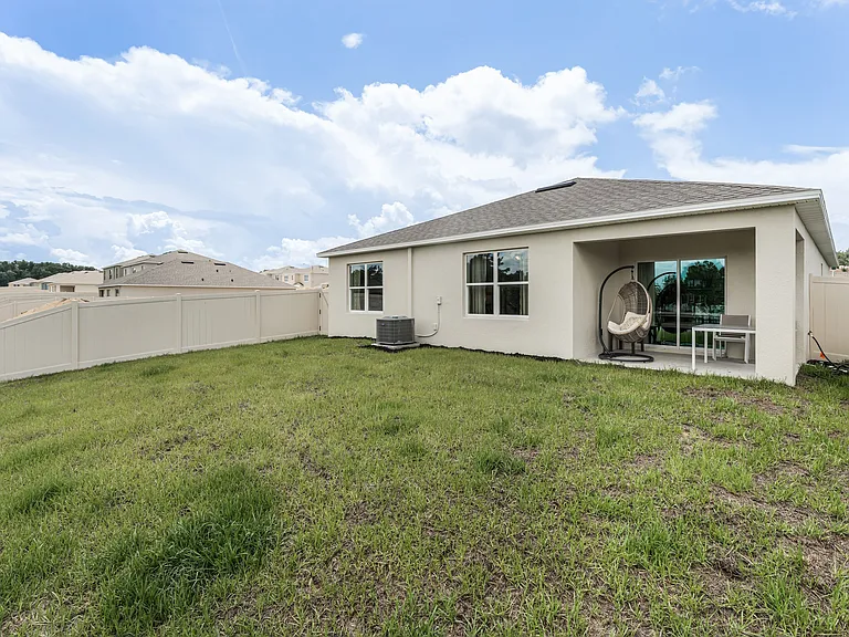 Spacious backyard with covered patio_perfect for lounging or entertaining.