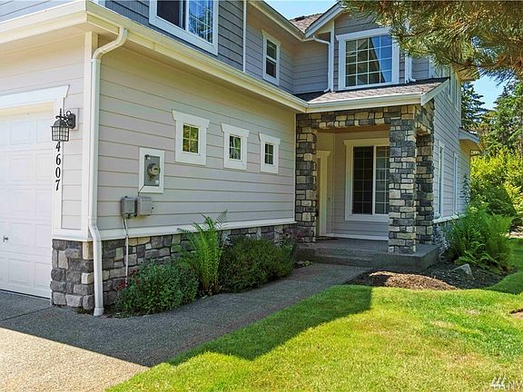 Stroll up to the covered front porch enjoying the mature landscaping surrounding you