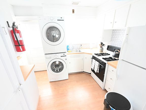Clean kitchen with brand new stove and brand new LG washer and dryer.