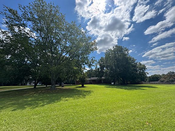 View from the large front lawn of pecan trees . Home sits way off the road .