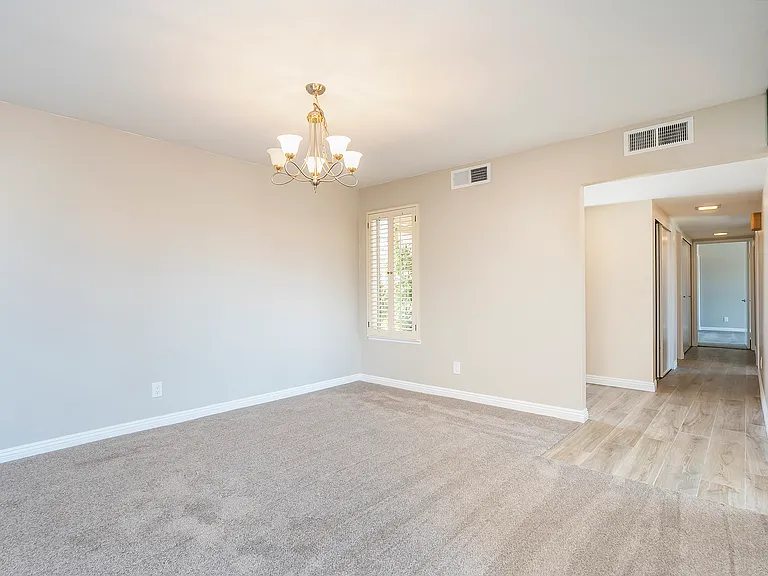 Dining area with a look down the main hall of the condo, leading to the laundry and two bedrooms.