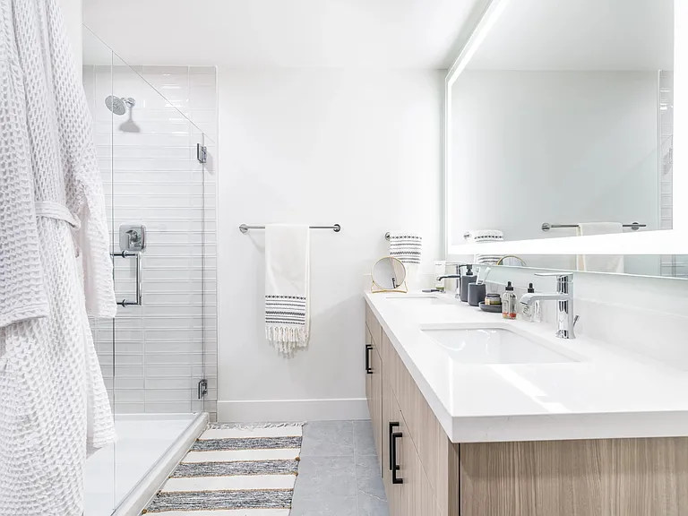 Discover designer bathrooms featuring quartz countertops and backlit mirrors, complemented by serene spa-like soaking tubs for your ultimate relaxation.