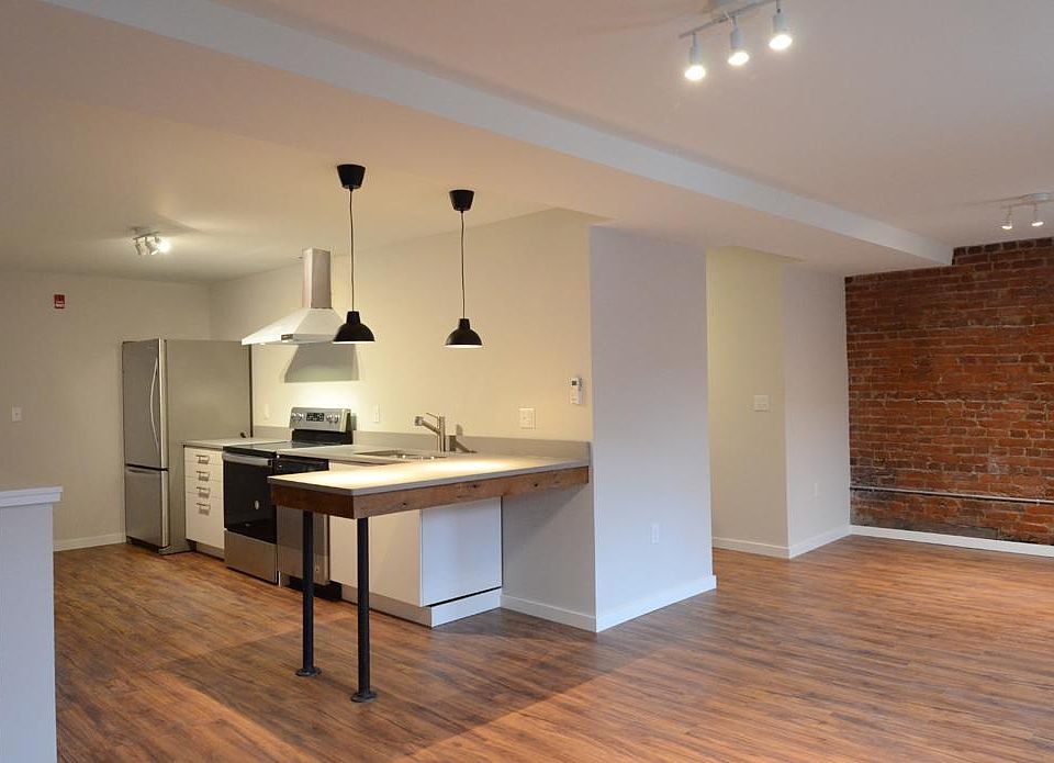 Galley kitchen with peninsula island and open living space.