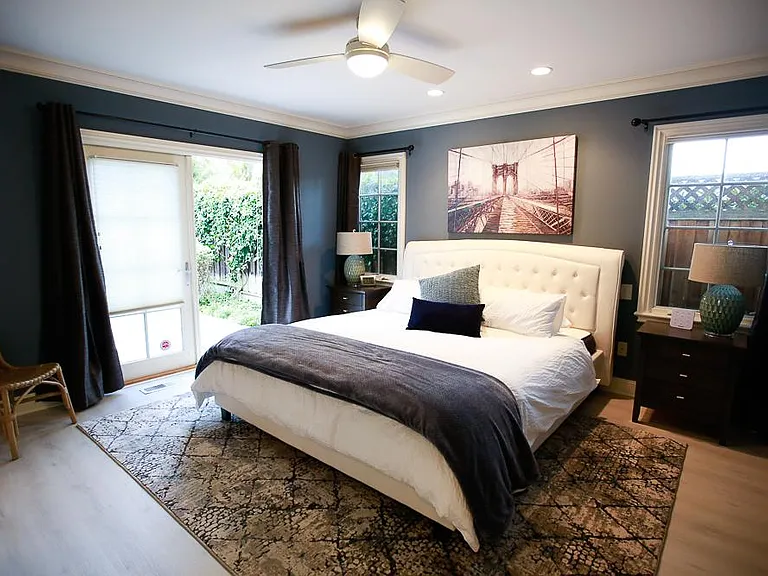 The Master bedroom features a very roomy, king-sized bed with a padded headboard.