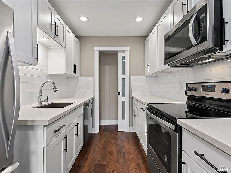 A chef-inspired kitchen showcases quartz countertops, custom shaker cabinetry, stainless steel appliances, and a clean, contemporary design.