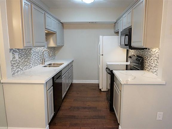 Freshly remodeled kitchen with new cabinets, sink, faucet, quartz counter tops and tile backsplash. Newer appliances and refrigerator stays with the property.
