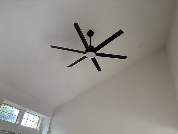 Ceiling fan showing high ceiling in living room