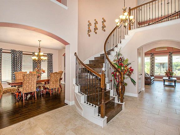 The beautiful entryway feature custom hardwood stairs and tile flooring.