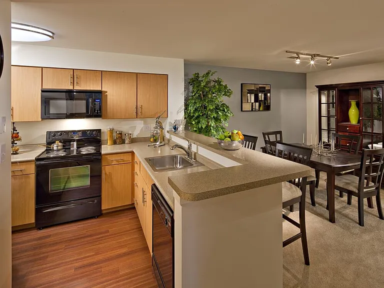 Classic Package kitchen with black appliances, grey laminate countertops, oak cabinetry, and hard surface flooring