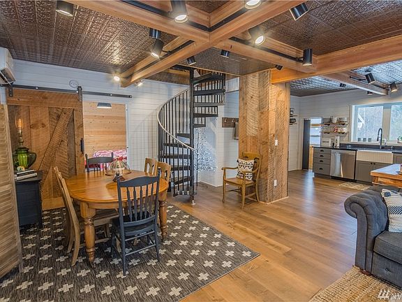 Tons of character in this renovated Roslyn home. Note the new laminate flooring throughout, faux tin ceiling tiles and track lighting.
