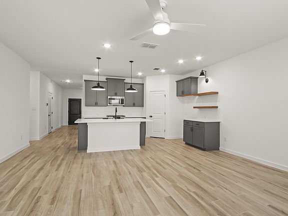 Kitchen with pendant lighting and floating shelves