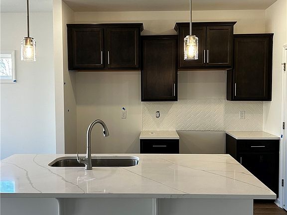 This bright kitchen features sleek countertops, st