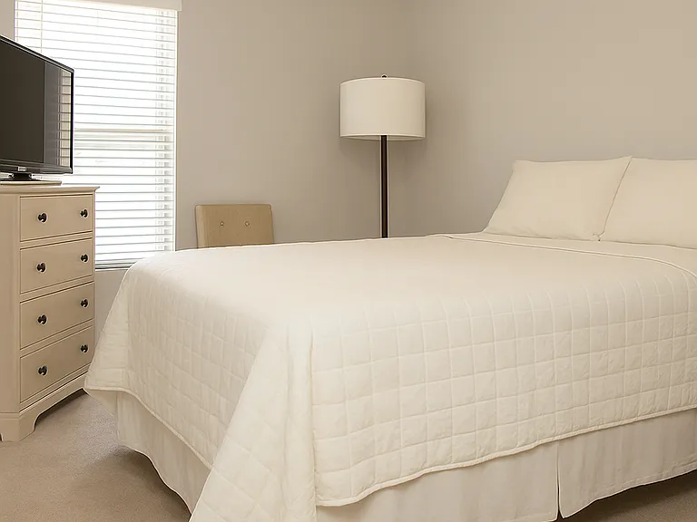Bright and comfortable guest bedroom with neutral tones and ample closet space.