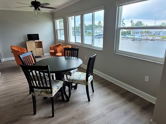 Enjoy waterfront views from the sunroom while sitting at the comfortable plush seats at the cafe dining/card table.