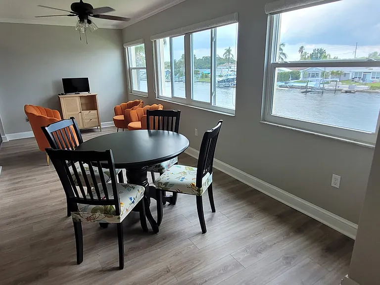 Enjoy waterfront views from the sunroom while sitting at the comfortable plush seats at the cafe dining/card table.