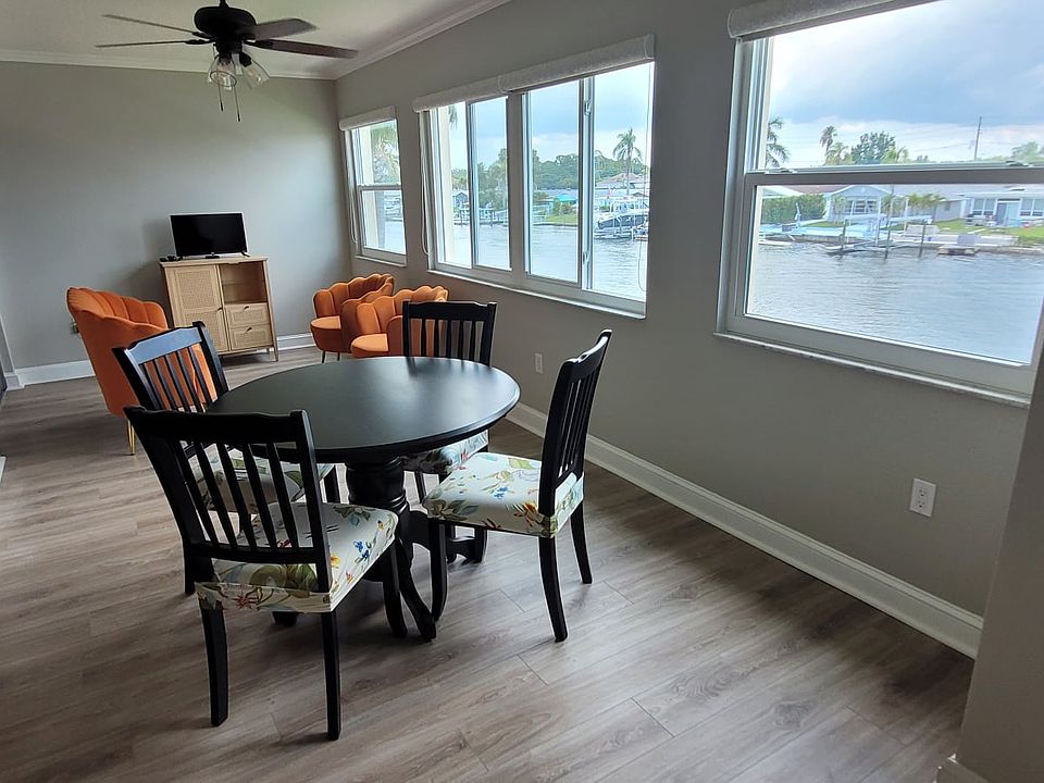 Enjoy waterfront views from the sunroom while sitting at the comfortable plush seats at the cafe dining/card table.
