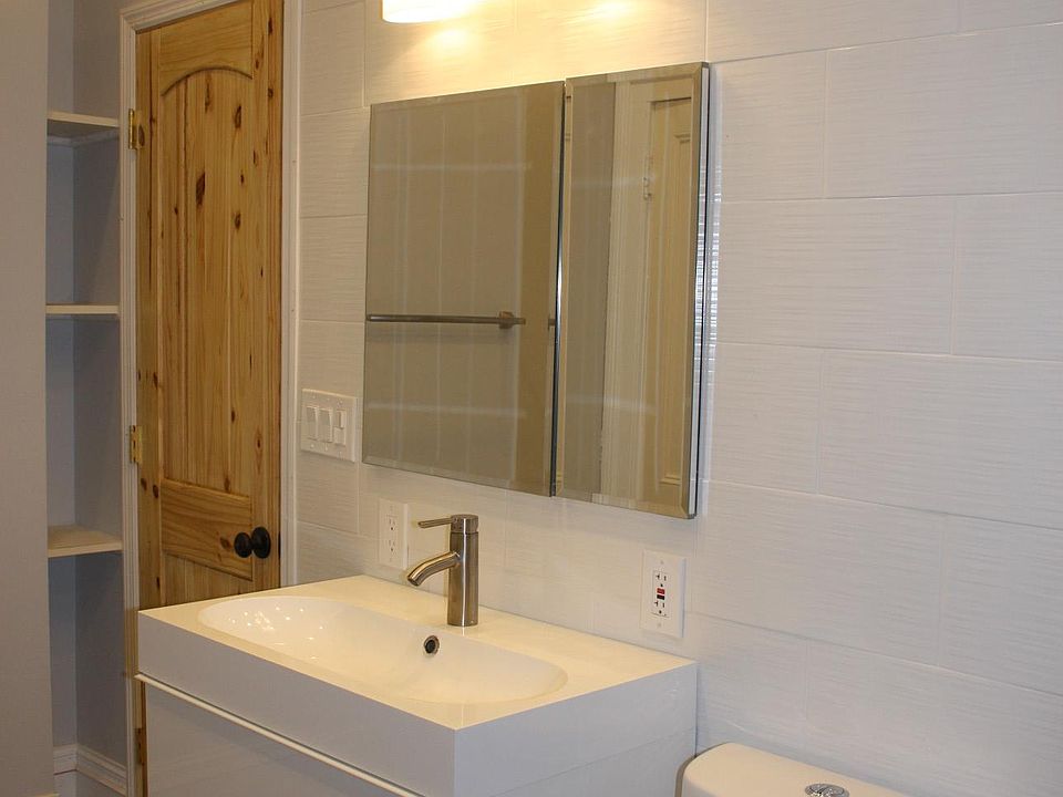 Ikea vanity with storage drawers. The sink wall is tiled from floor to ceiling in Italian porcelain tile.