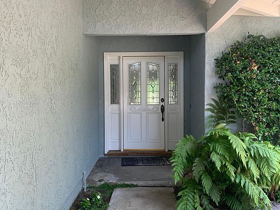 Covered, lush entry leading to beautiful front door