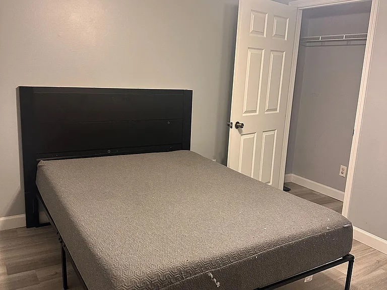 Furnished bedroom with a full bed, ceiling fan, and a closet with shelving for convenient storage.