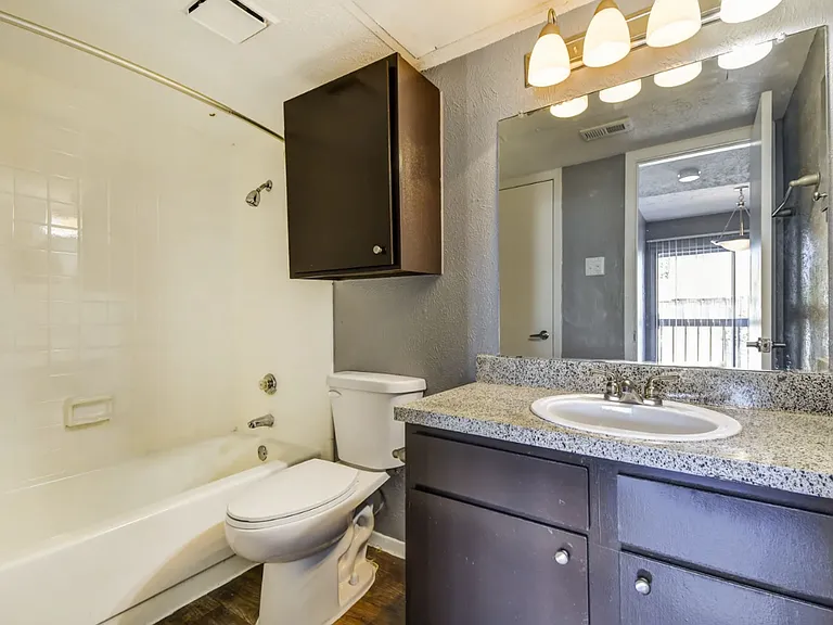 Clean and modern bathroom featuring a stylish vanity, updated lighting, and full tub/shower combo.