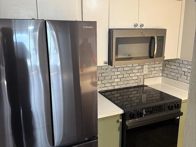 Remodeled kitchen with new appliances and custom backsplash.