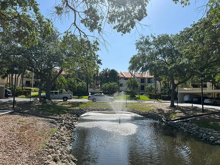 Community pond and carports in front of condo building