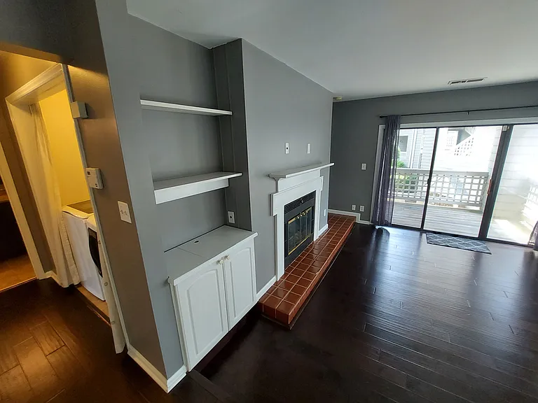 Enjoy the hardwood flooring, wood-burning fireplace, shelving, cabinet, and full windows, including a sliding door.