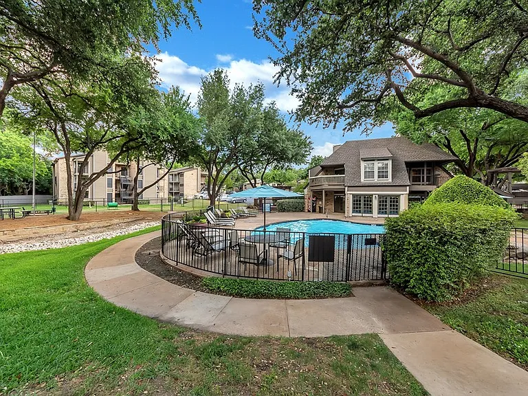 Beautiful landscaped courtyard and community pool area with mature shade trees