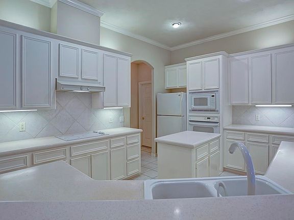 This large open kitchen has 12" tile back splash and under cabinet lighting.