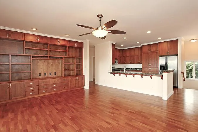 Great room towards entertainment center and kitchen and stairwell to garage and laundry