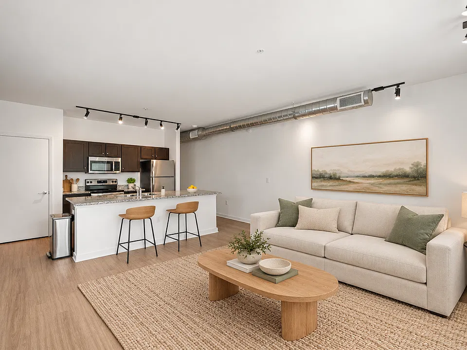 Spacious living room and kitchen with island countertop and stainless steel appliances