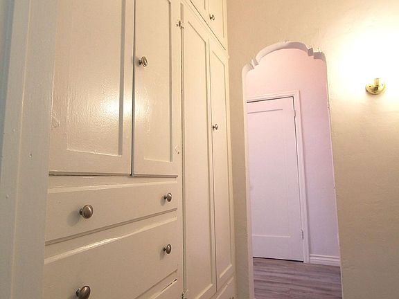 Vanity area with built in dressers and armoire.
