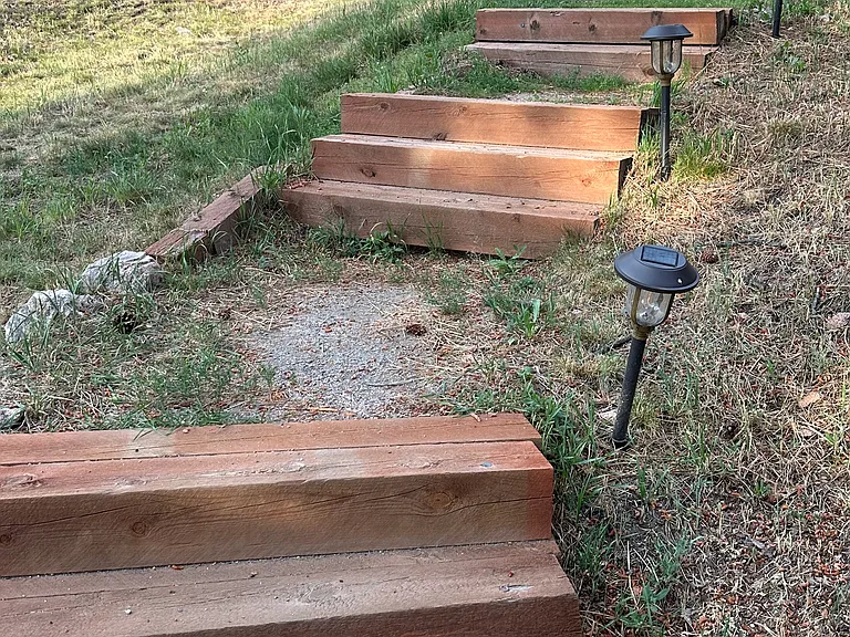 Stairs going from driveway parking spot down to lower level West unit