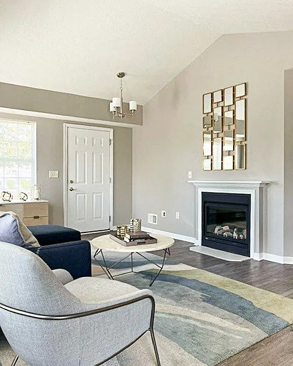 View of living area in ranch townhome great room with fireplace, cathedral ceiling, and faux hardwood floors