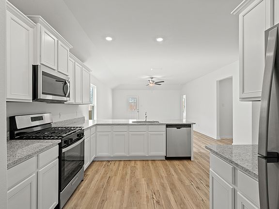 Enjoy stunning granite countertops and designer wood cabinetry in this kitchen.