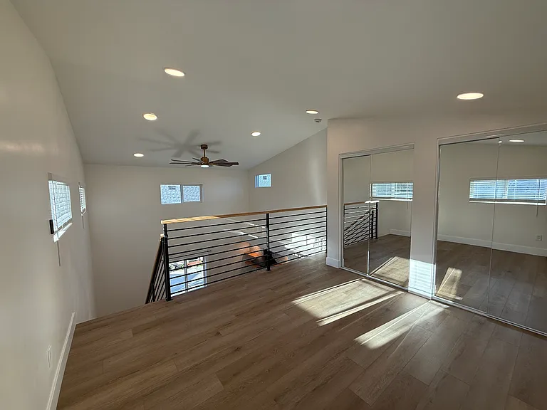 Loft space with ceiling fan visible in distance (lies above kitchen)