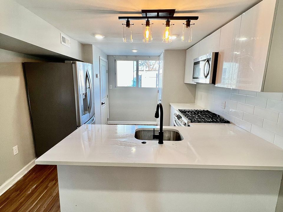 brand new kitchen with white quarts top breakfast bar.