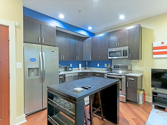 Furnished kitchen with 4-top dining seating. Dishwasher, range, microwave, and refrigerator.