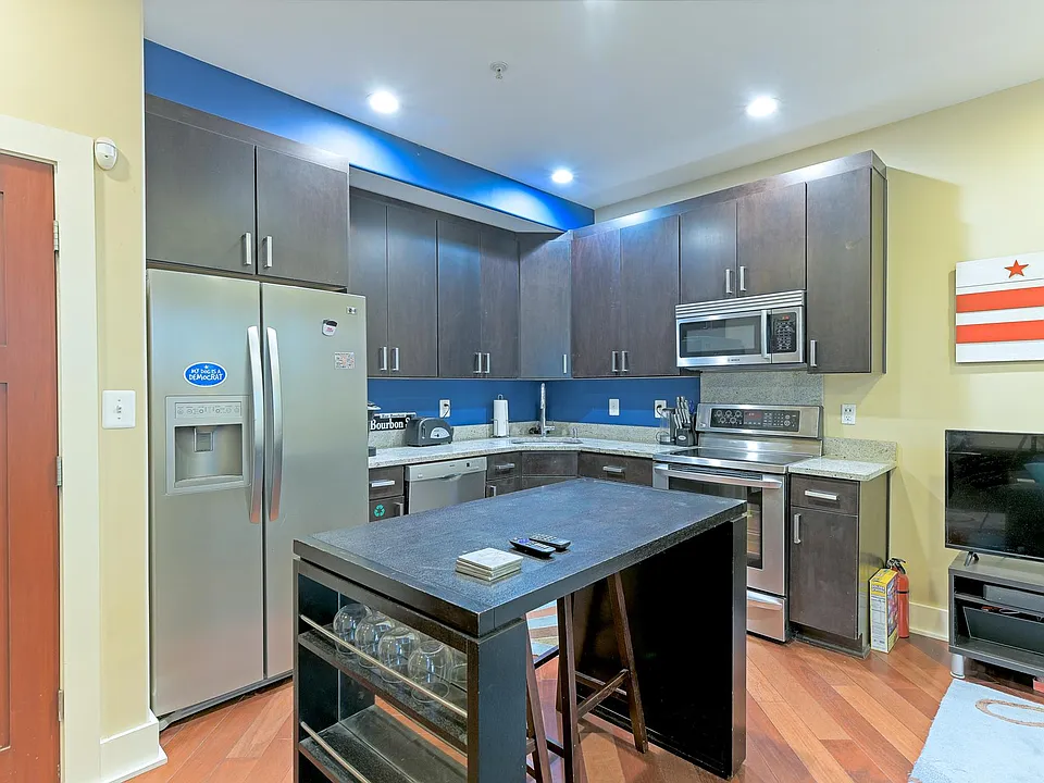 Furnished kitchen with 4-top dining seating. Dishwasher, range, microwave, and refrigerator.