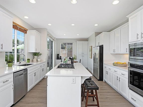 Kitchen with new quartz countertops, new appliances, paint, LVP flooring, baseboards, window