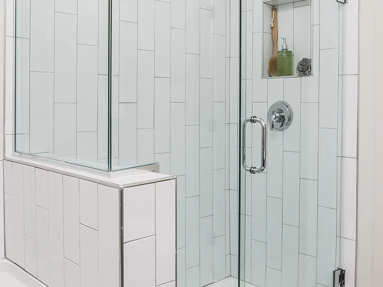 Frameless glass showers with floor-to-ceiling tile surrounds