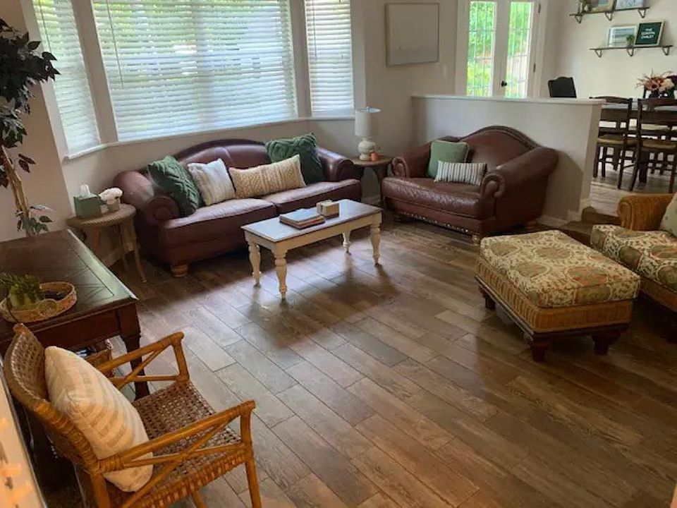 Living room with TV open to dining area and access to backyard patio