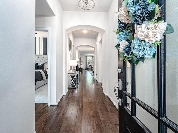 Upon entering you find a welcoming corridor showcasing beautiful floors, elegant archways, high ceilings, and ample lighting!