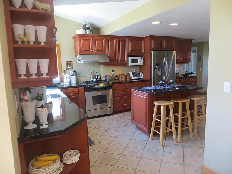 View from dining room into kitchen with island, gas range, s