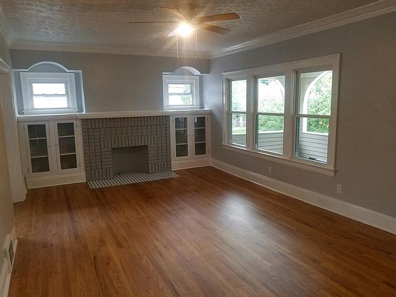 Living room with decorative fireplace, book shelves and view
