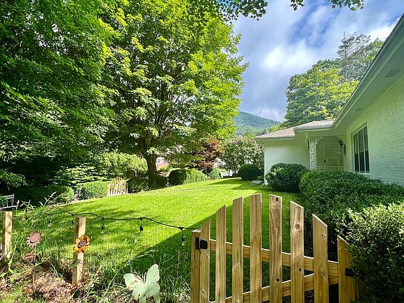 White brick cottage within walking distance to ASU and downtown Boone with flat front yard with large maple trees.