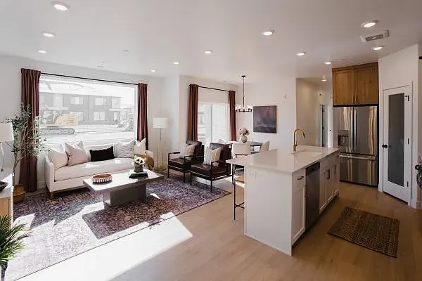 Staged photo. Condo has white cabinets with black hardware.