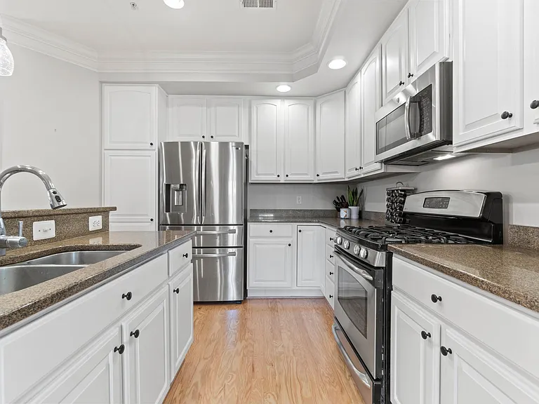 kitchen with double sink, high end stainless appliances, gas stove, granite counter tops, and 42 " cabinets